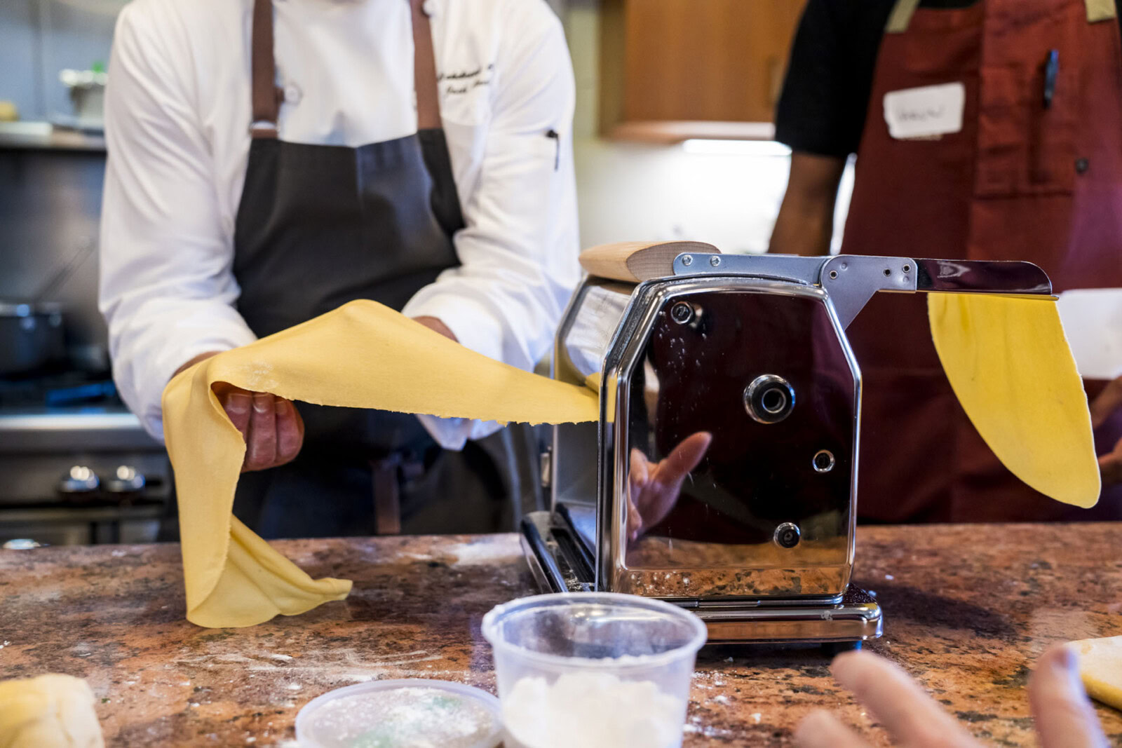 A bread baker using a pasta machine to make dough at Cakebread Cellars.