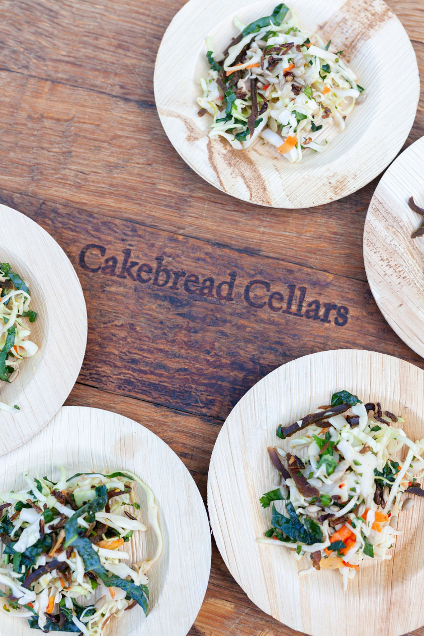 Fresh vegetable salads served on wooden plates at Cakebread Cellars, showcasing vibrant greens, carrots, and shredded cheese.