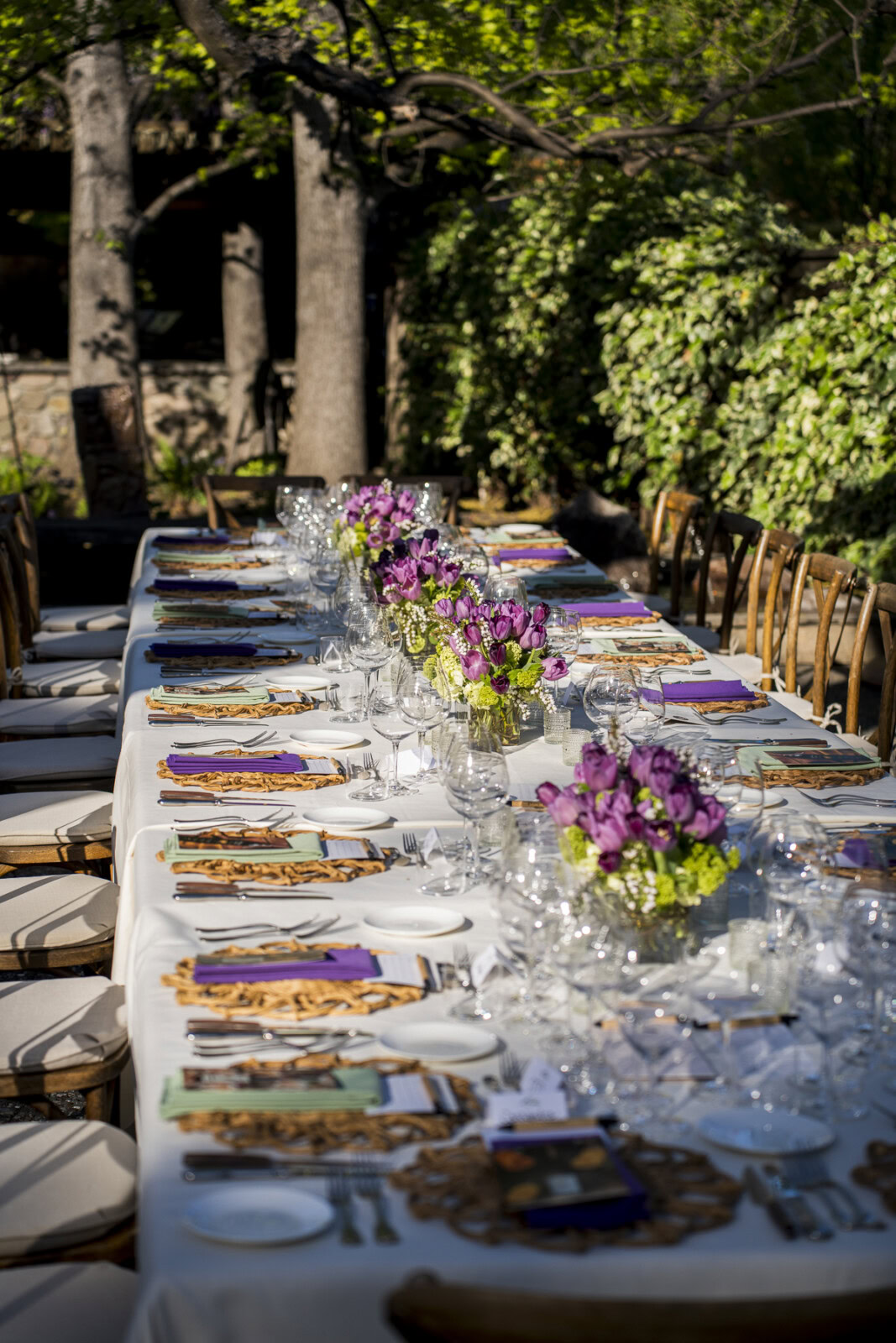 Elegant outdoor dining table set with floral centerpieces, glassware, and place settings at Cakebread Cellars.