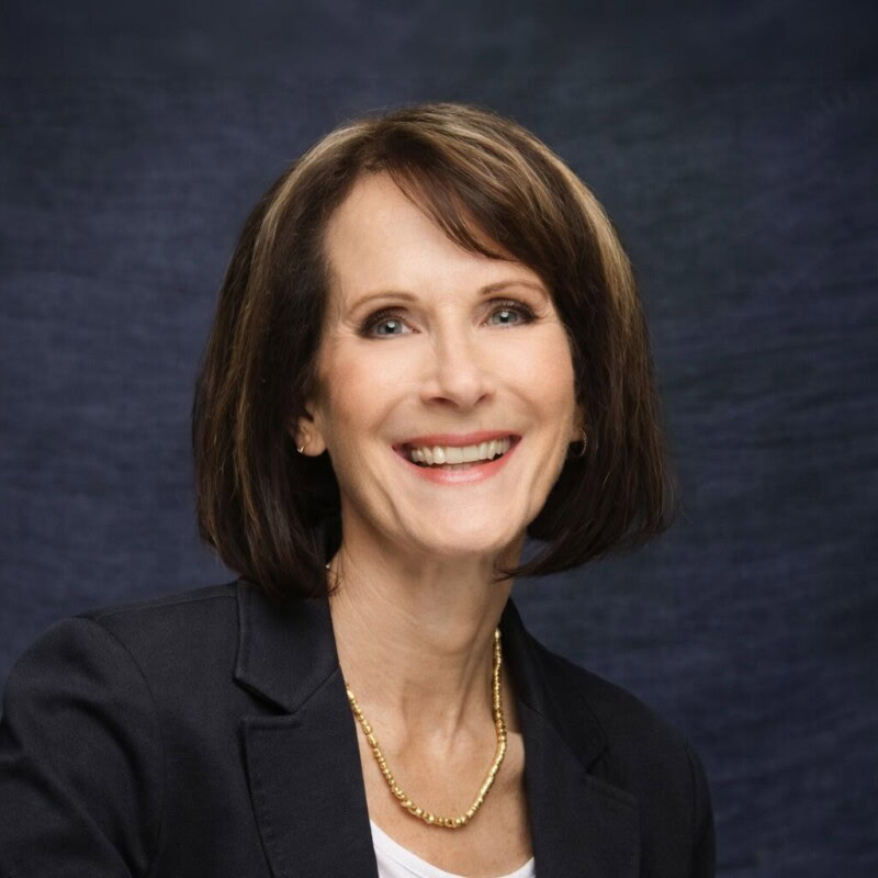 A portrait of Kathy DeVillers from Cakebread Cellars, wearing a dark blazer and smiling at the camera.