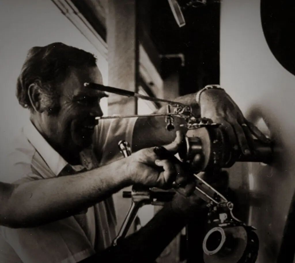 A woman looking through a telescope or microscope, focusing intently on her work in a laboratory or research setting.