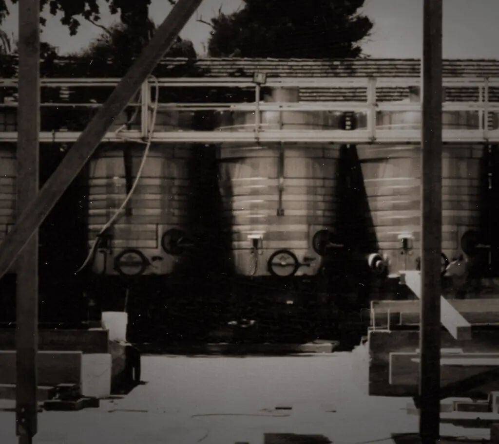 Industrial wine fermentation tanks at Cakebread Cellars winery, California, in black and white.