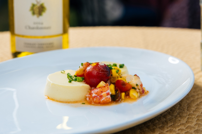 Corn panna cotta with tomatoes and lobster on a white plate